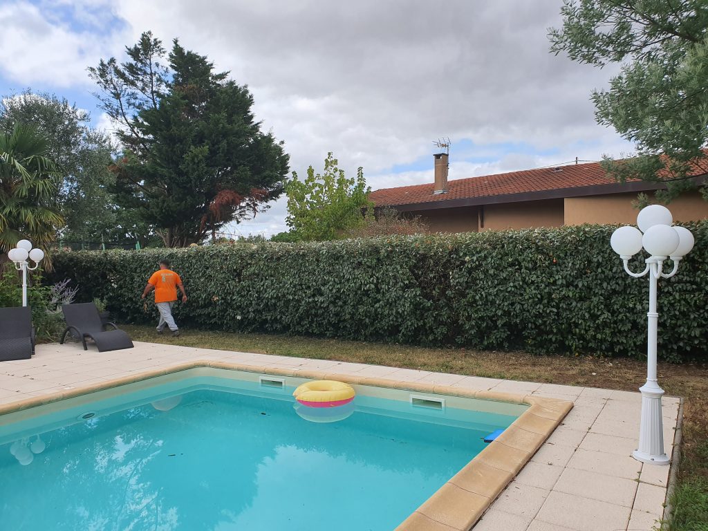 Après l'intervention de RC Espaces Verts, taille de haie et débroussaillage réalisés autour de la piscine, résultat soigné et professionnel.